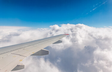 Obraz premium View from the airplane window at a beautiful cloudy sky and the airplane wing