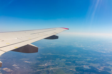 Obraz premium View from the airplane window at a beautiful blue clear sky and the airplane wing