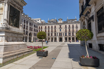 Santander, Spain. Full view of the bronze statue of Captain Pedro Velarde on a stone pedestal at the entrance to Plaza Porticada, with Neoclassical portico and surrounding arcaded buildings