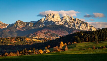 Naklejka premium Autumnal mountain vista, sunlit valley, colorful foliage