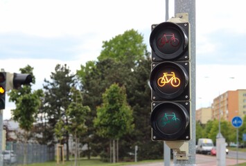 The traffic light for cyclists on the cycle path is glowing orange, cyclist prepare yourself.