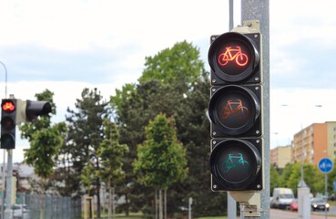 The traffic light for cyclists on the bike path is red, the cyclist must stop.