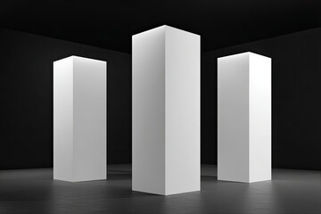 Three tall, blank, white rectangular pillars in a dark room
