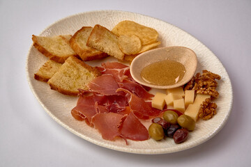 A beautifully arranged platter featuring an assortment of meats, cheeses, and snacks, perfect for an elegant gathering or a casual culinary experience.