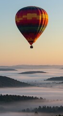 Fototapeta premium Hot air balloon over misty mountains