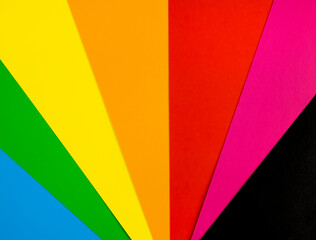 Brightly coloured sheets of paper arranged in a fan shape. A fan made of coloured paper.