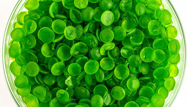 Lush Green Candy: A close-up shot reveals a vibrant, inviting array of green candies, each disc shimmering within a clear glass container, capturing the irresistible allure of the sweet treat.