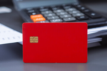 Red credit card with calculator and a payment schedule. Financial concept for credit card usage, loan calculations, monthly payment planning and interest rates.