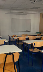 Vertical empty classroom with high-tech whiteboards and ergonomic chairs.