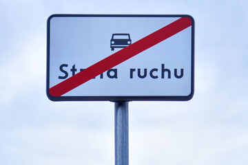 White road sign with red diagonal stripe reading “Strefa ruchu” indicating end of traffic zone.