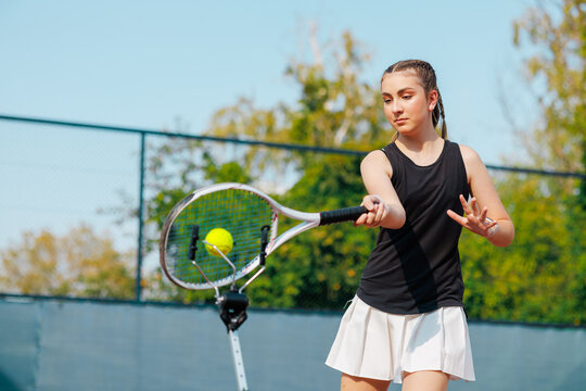 Focused Young Female Tennis Player Returning Ball on Court During Training or Tournament - Powered by Adobe