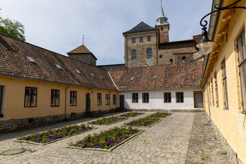 Stone buildings and courtyard with flowers at Akershus fortress in Oslo, Norway