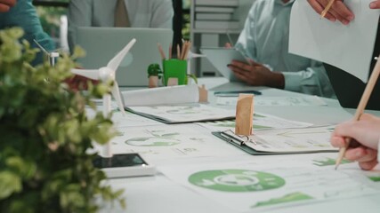 A vibrant office scene featuring a diverse team actively collaborating on sustainability projects, surrounded by modern digital devices and green elements, showcasing innovation and teamwork. SACTR - Powered by Adobe