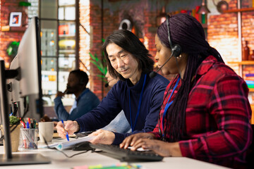 Fototapeta premium Call center managers developing strategies to improve customer loyalty, looking over paperwork. Customer support management team implementing procedures for better client issue resolution