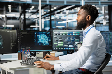 Computer scientist inspecting neural network data center used for machine learning. African american man doing maintenance on server hub to optimize it for artificial intelligence workloads