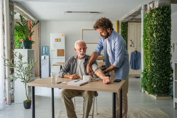 Son help and checking blood pressure of senior man father at home