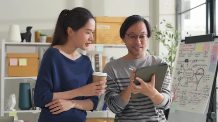 business development teamwork is standing and discussing a new rebranding and strategy. The two business people focus on the future target market and present success, using market research data