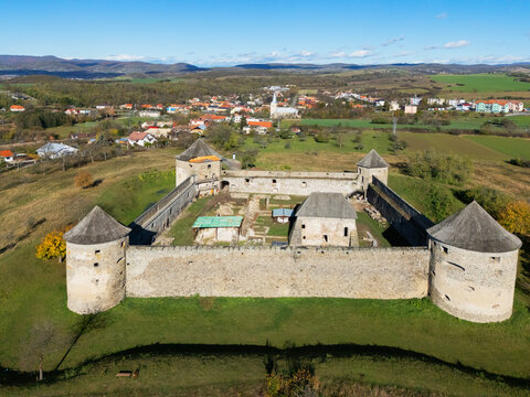 Aerial view of the ancient Bzov&Atilde;&shy;k Monastery fortress, its stone walls standing resilient against time, with the village nestled in the valley, Bzov&Atilde;&shy;k, Krupina, Slovakia.