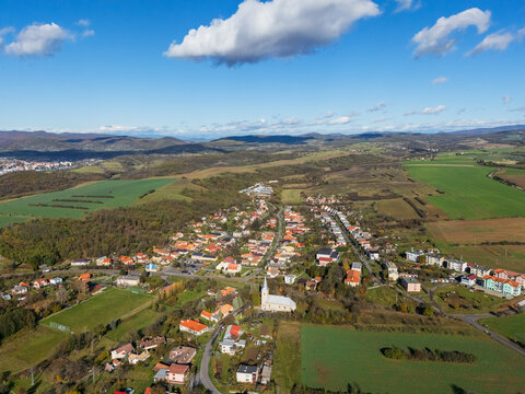 Aerial view of the Bzov&Atilde;&shy;k Monastery's white facade and spire piercing the skyline amidst a tapestry of green fields and autumnal forests, Bzov&Atilde;&shy;k, Krupina.
