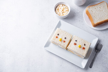 Japanese Egg Salad sandwich, Tamago Sando in the form of funny face on a white background