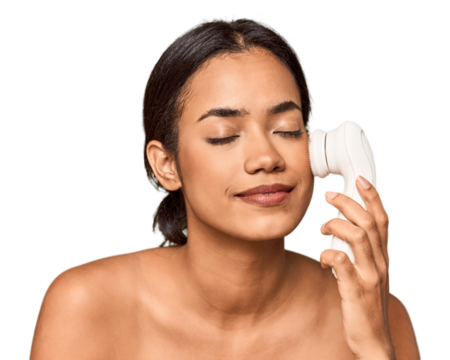 Young Filipino woman using electric facial cleanser