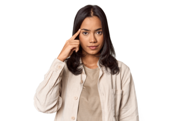 Portrait of a young Filipino woman pointing temple with finger, thinking, focused on a task.