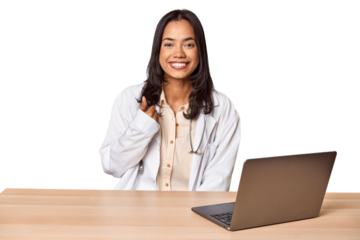 Young Filipino doctor with laptop in studio smiling and raising thumb up