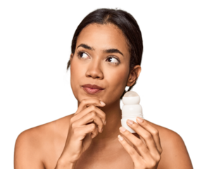 Filipino woman holds deodorant in studio looking sideways with doubtful and skeptical expression.