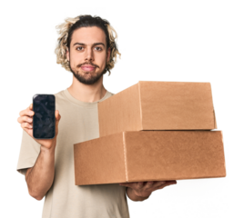 Young Caucasian man receiving packages, on phone in studio