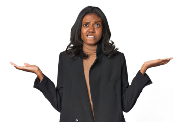 Young Indian woman in business suit confused and doubtful shrugging shoulders to hold a copy space.