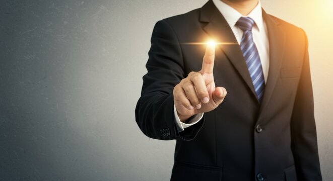 Hand of a businessman in a suit pressing a glowing digital button on a dark background, symbolizing innovation and technology