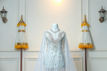 Stunning white bridal gown with intricate lace, pearls, and long tulle sleeves, perfect for a traditional akad nikah or elegant wedding.