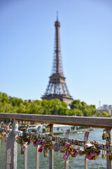 Romantic padlocks on Paris bridge with Eiffel Tower in background on sunny summer day