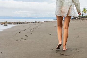 Tourist walking on a colombian beach leaving footprints in the sand
