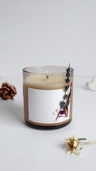 Beige Candle in Glass Jar Decorated with Dried Lavender on White Surface