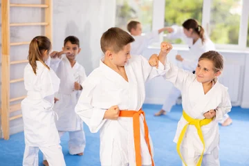Fototapete Rund Kampfkunst Child boys and girls partners during martial arts karate class train to perform basic blows to opponent with hands and feet. Preparation of athletes for competitions  © JackF