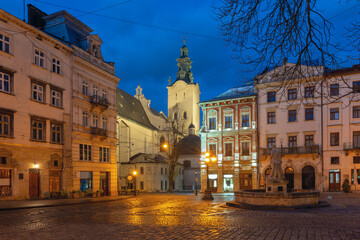 Fototapeta premium Historic buildings and cafes on Market Square in Lviv, Ukraine, at dawn with street lights on