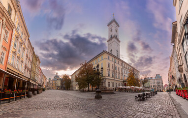 Fototapeta premium Historic buildings and cafes on Market Square in Lviv, Ukraine, at dawn with street lights on