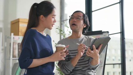 business development teamwork is standing and discussing a new rebranding and strategy. The two business people focus on the future target market and present success, using market research data