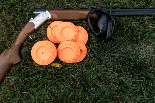 shotgun and clay targets in grass during trap shooting 