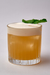 A Refreshing Cocktail Served in a Clear Glass with a Frothy Top and a Garnish of Fresh Mint Leaves for a Perfect Summer Drink Experience