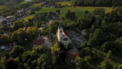Sommerliche Panoramaansicht von Ortenburg im Landkreis Passau. Die historische Kirche, Friedhof und das bayerische Dorf ergeben ein harmonisches Bild aus Glaube, Natur und Tradition.
