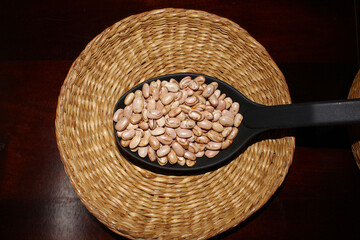 Spoon of carioca beans on the wicker basket. Brazilian food.