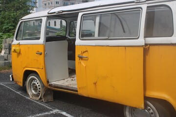 Old abandoned yellow minibus in parking lot