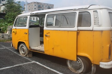 Old abandoned yellow minibus in parking lot