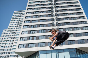 A girl jumps on an outdoor trampoline.