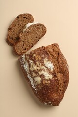 Pieces of fresh rye bread on beige background, flat lay