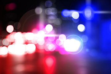 Police red and blue lights in city at night, blurred view