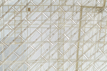 Modern architectural interior ceiling with grid. Intricate metal framework creates repeating geometric patter
