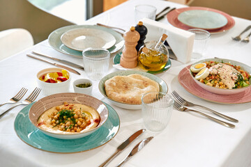 A Beautifully Set Dining Table Featuring A Variety of Exquisite Dishes Including Salads, Bread, Olives, and Desserts Perfect for Enjoying a Gourmet Meal